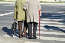 Old couple walks on the pedestrian crossing
