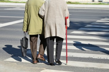 Old couple walks on the pedestrian crossing