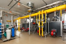 Interior gas boiler with a water treatment system, a lot of boilers, pipes and sensors.