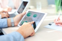 Business person analyzing financial statistics displayed on the tablet screen