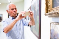 Man photographing painting in museum