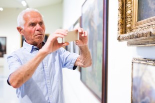 Man photographing painting in museum