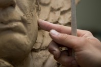Sculptor artist creating a bust sculpture with clay