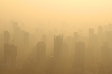 Buildings under construction with cranes in misty morning, Bangkok, Thailand