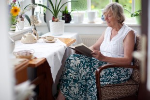 Seniorin lesend im Sessel