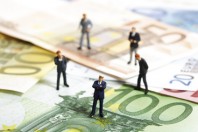 Figuren stehen auf Euro-Banknoten