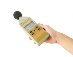 old sound level meter holding on hand