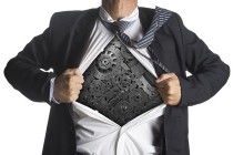 Businessman showing a superhero suit underneath machinery metal