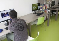 Jeune migrant utilisant le matériel informatique de la médiathèque Don Quichotte de Saint-Denis pour rester en contact avec sa famille.