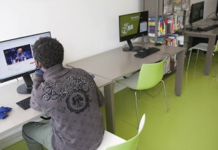 Jeune migrant utilisant le matériel informatique de la médiathèque Don Quichotte de Saint-Denis pour rester en contact avec sa famille.