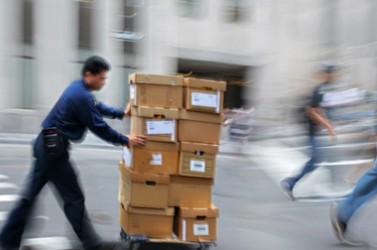 Livreur poussant un chariot avec des cartons